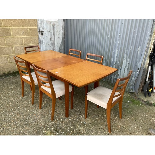 144 - An extending teak dining table together with a set of six dining chairs max size 200x90x77