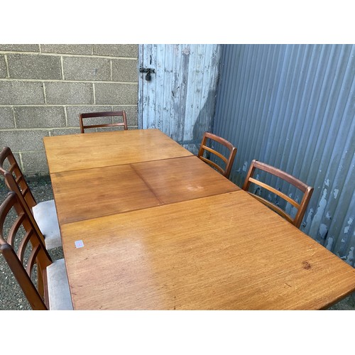 144 - An extending teak dining table together with a set of six dining chairs max size 200x90x77