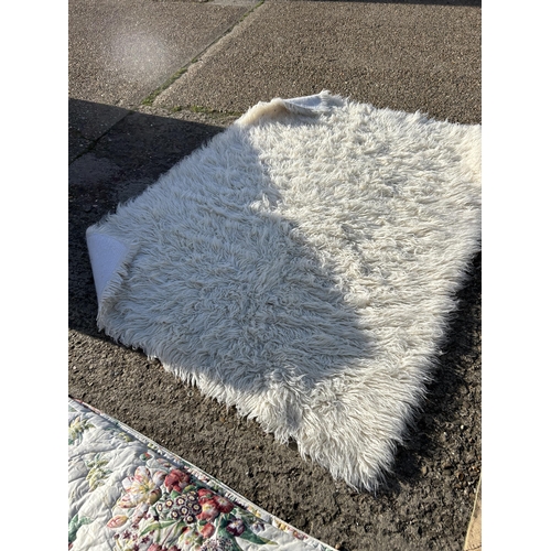 169 - A floral king size bed quilt, fluffy rug and beige rug