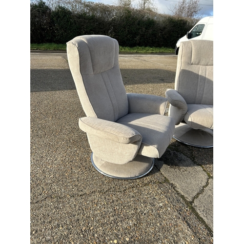 114 - A pair of modern swivel and recline armchairs in light grey upholstery