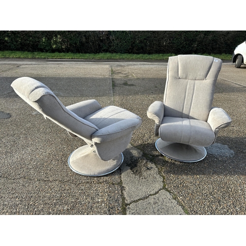 114 - A pair of modern swivel and recline armchairs in light grey upholstery