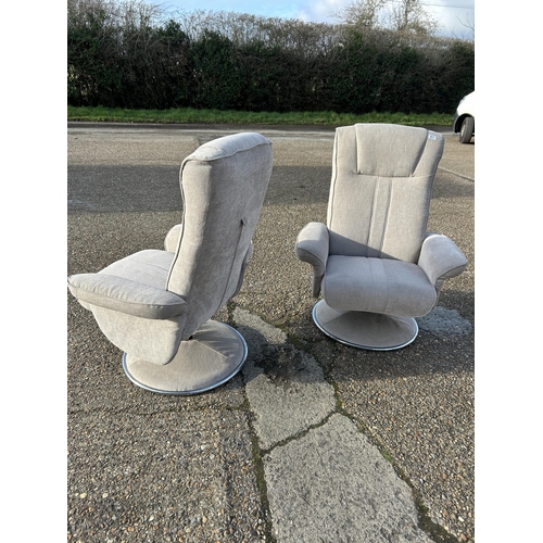 114 - A pair of modern swivel and recline armchairs in light grey upholstery