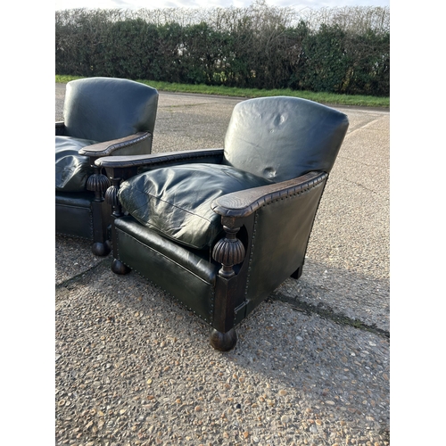 115 - A pair of oak framed club style chairs with green leather upholstery