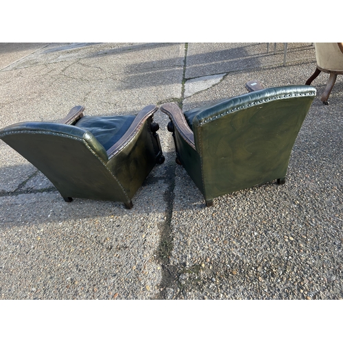 115 - A pair of oak framed club style chairs with green leather upholstery