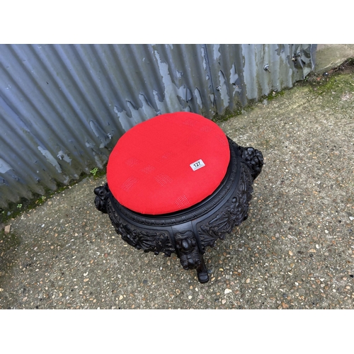 127 - A large carved stool with red upholstered top 65 diameter x 55 high