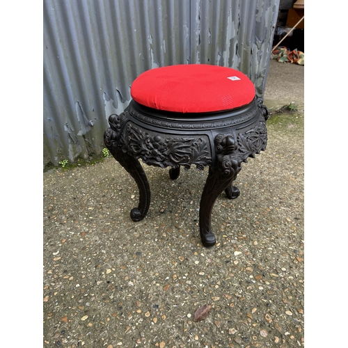 127 - A large carved stool with red upholstered top 65 diameter x 55 high