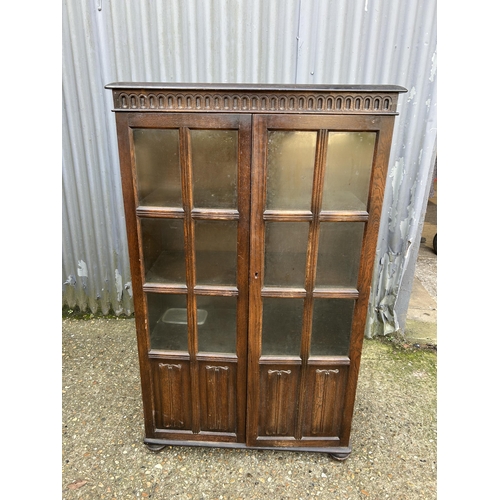 147 - A glazed oak two door cabinet 80x35x132