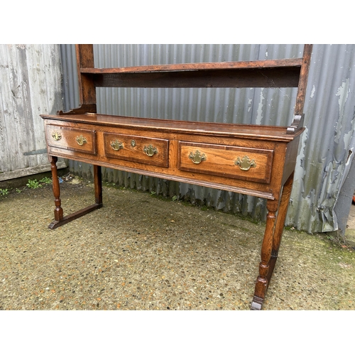 231 - A oak three drawer dresser with plate rack top 152cm wide