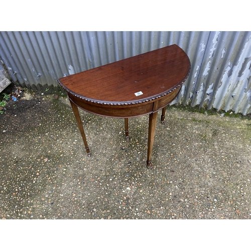 36 - A mahogany demi lune card table with green baize