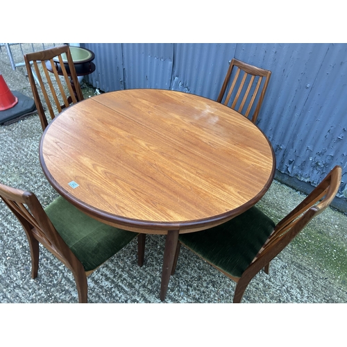 42 - A circular g plan teak dining table together with a set of four g plan high back  dining chairs