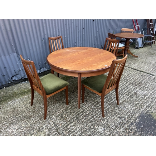 42 - A circular g plan teak dining table together with a set of four g plan high back  dining chairs