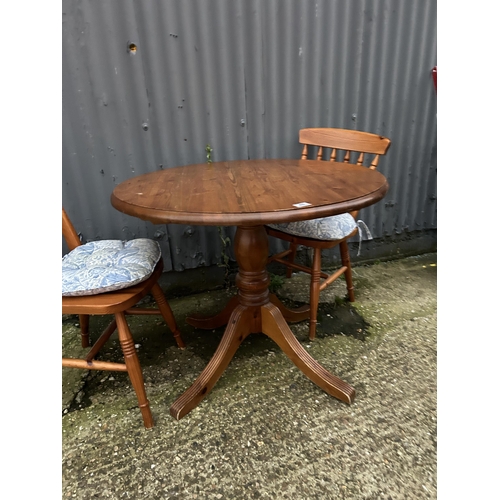 48 - A circular pine table and two chairs 90cm diameter