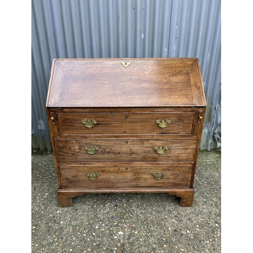 73 - An early victorian mahogany bureau with fitted interior and original Key