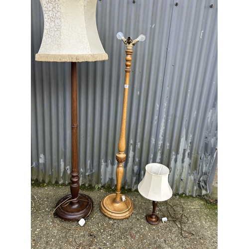 81 - Three oak floor standing lamps and an oak table lamp