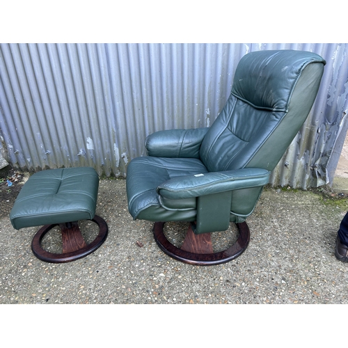 99 - A green leather recliner chair and stool by UNICO