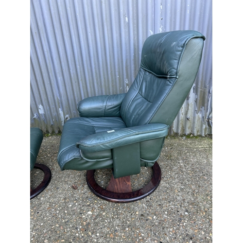 99 - A green leather recliner chair and stool by UNICO