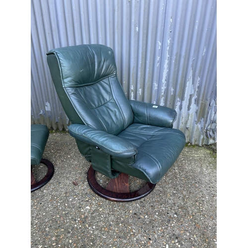 99 - A green leather recliner chair and stool by UNICO