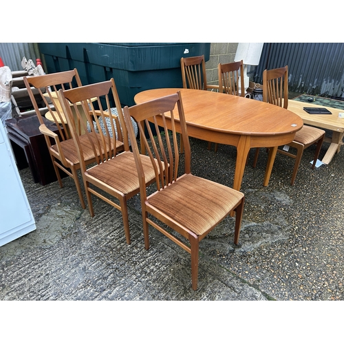 173 - A mid century teak extending dining table with six chairs