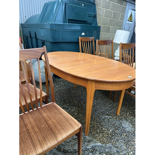 173 - A mid century teak extending dining table with six chairs