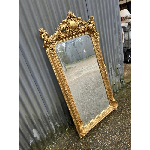 247 - An ornate gold gilt framed mirror with cherub decoration 80x160