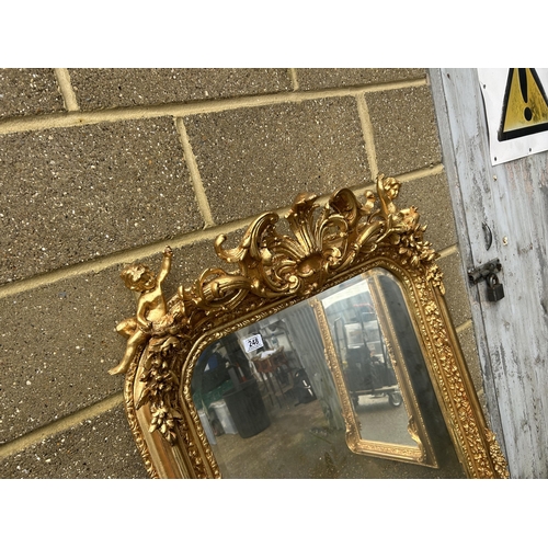 248 - An ornate gold gilt framed mirror with cherub decoration 80x161