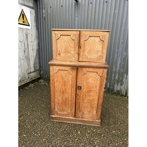 267 - An unusual aesthetic style oak cupboard carved to the front, converted to drinks storage  74 x50x130