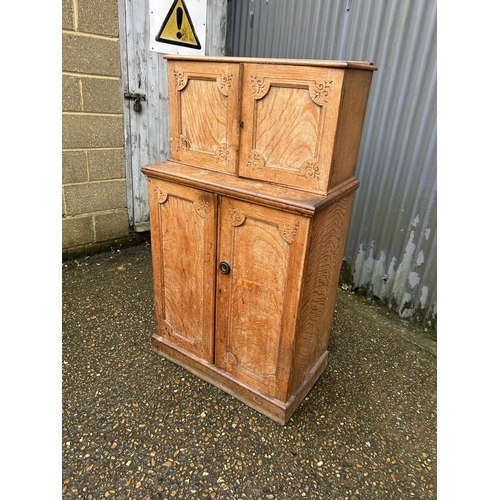 267 - An unusual aesthetic style oak cupboard carved to the front, converted to drinks storage  74 x50x130