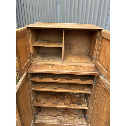 267 - An unusual aesthetic style oak cupboard carved to the front, converted to drinks storage  74 x50x130