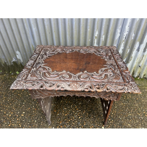 286 - An ornate Chinese carved hardwood folding table 77x60