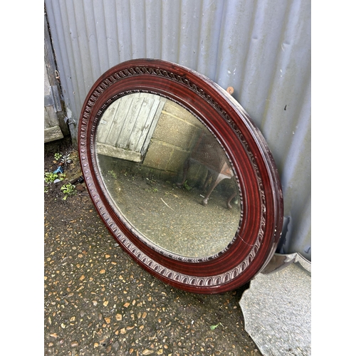 307 - An oval mahogany framed mirror together with a frameless mirror