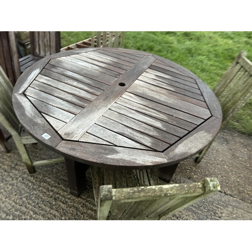 421 - A hardwood circular garden table and six chairs