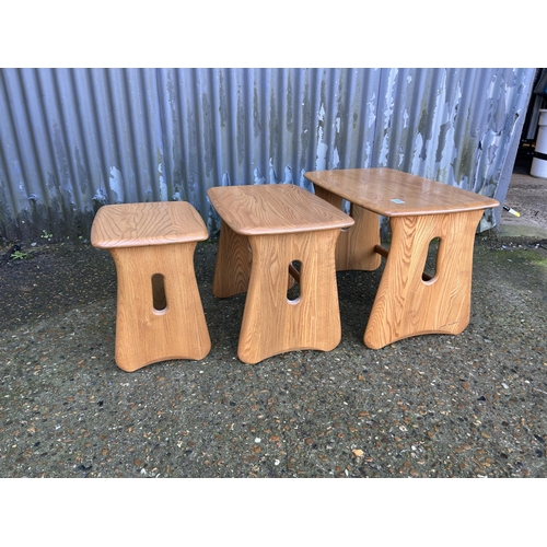 48 - An ercol light elm nest of three occasional tables