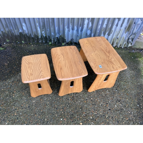 48 - An ercol light elm nest of three occasional tables