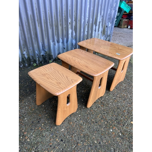 48 - An ercol light elm nest of three occasional tables