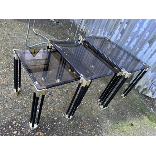 54 - A chrome circular side table together with a smoked glass nest of three