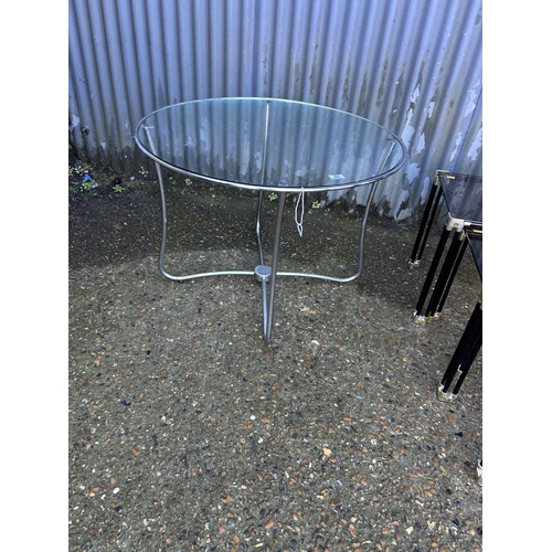 54 - A chrome circular side table together with a smoked glass nest of three