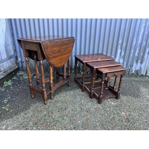 69 - An oak gateleg table together with a oak nest of three