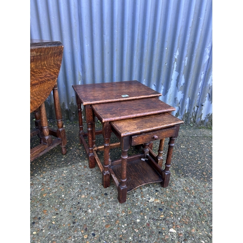 69 - An oak gateleg table together with a oak nest of three