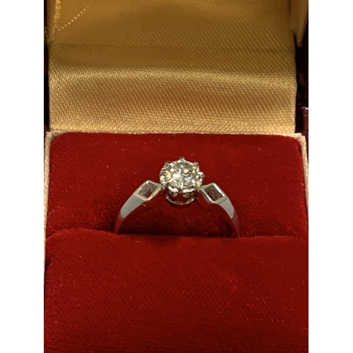 869 - An 18ct White Gold illusion set solitaire Diamond ring, claw set to pierced lozenge shaped shoulders... 