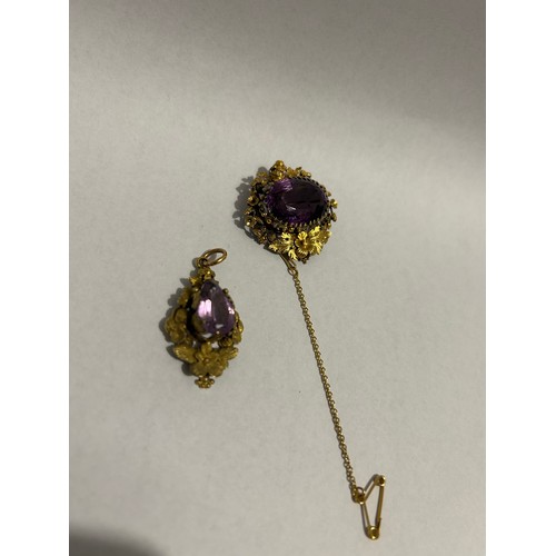 893 - A Victorian single stone amethyst set brooch, an oval cut amethyst claw set to a floral and scrollin... 