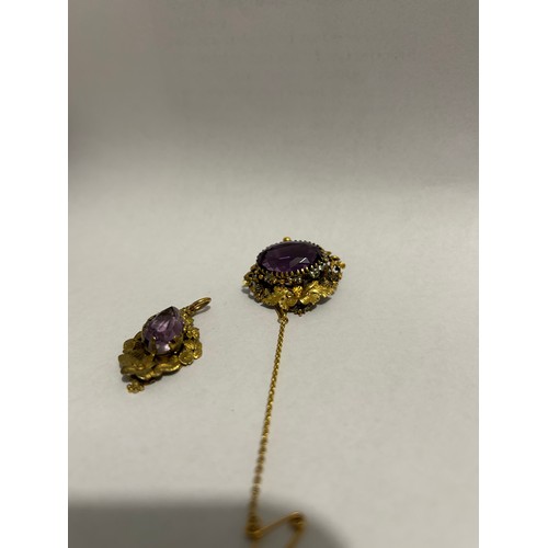 893 - A Victorian single stone amethyst set brooch, an oval cut amethyst claw set to a floral and scrollin... 