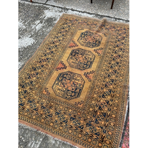 154 - A red oriental pattern rug together with a gold pattern rug (Largest)130x190