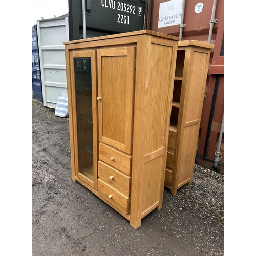 25 - A glazed light oak bookcase cabinet with three drawers 106x40x155