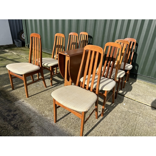 312 - A mid century teak gateleg dining table together with a set of 8 teak high back dining chairs