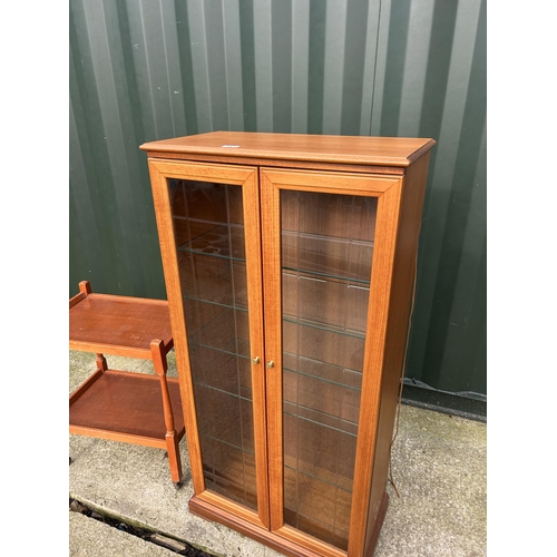 317 - A teak two door cabinet together with a tea trolley