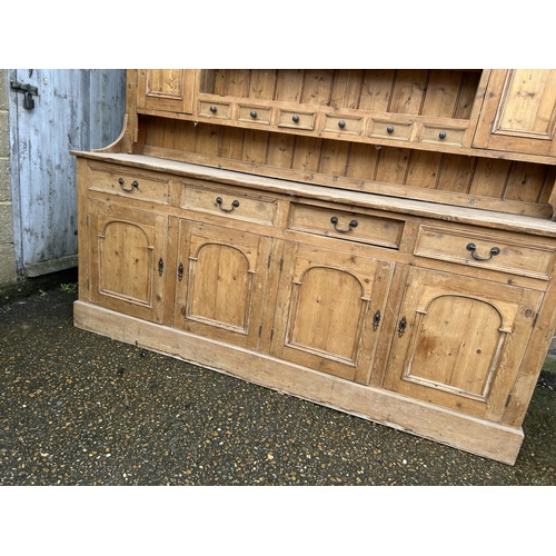 59 - A large antique pine dresser with four drawers and four door base 211x50x225