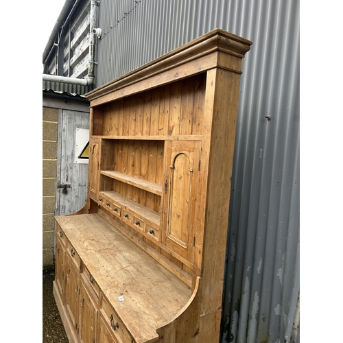 59 - A large antique pine dresser with four drawers and four door base 211x50x225