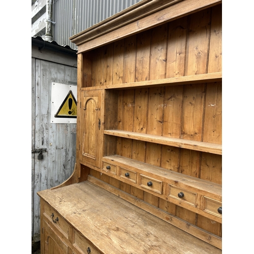 59 - A large antique pine dresser with four drawers and four door base 211x50x225