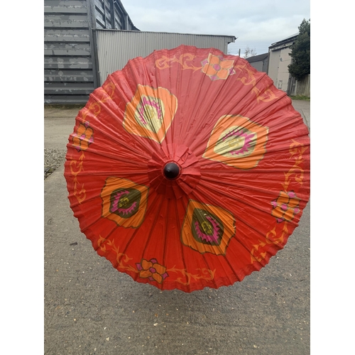 556 - 3 Large oriental fans and a Thai parasol