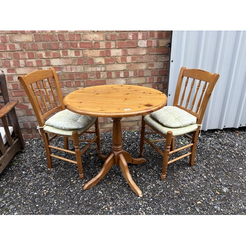 317 - A circular pine table with two chairs 77cm diameter